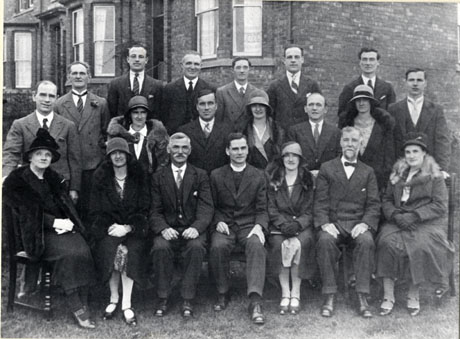 Photograph of the members of the Parochial Church Council of the Parish of St. Andrew, Blackhall, taken outside a large bay-windowed house;the group consists of twelve men, wearing suits, seven women, wearing overcoats and hats, and the clergyman in the middle of the front row