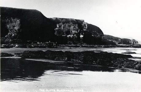 Postcard photograph, entitled The Cliffs, Blackhall,showing the cliffs in the distance, looking north; they are seen across a short stretch of beach at low tide