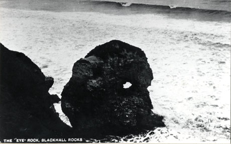 Postcard photograph entitled The Eye Rock, Blackhall Rocks showing the rock, a piece of rock with a hole through its middle, close up, surrounded by sea