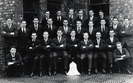 Photograph of the members of the Blackhall Bell Club Billiards and Snooker teams; the twenty five members of the teams are photographed outside a brick building with a bell-shaped object in front of the group; all the men are wearing suits