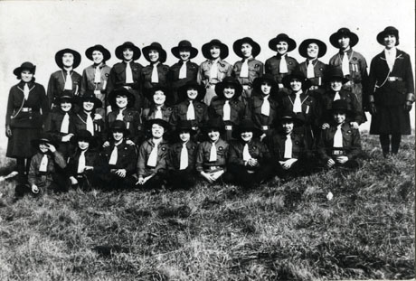 Group photograph of the members of the First Blackhall Guide Troup; the twenty eight Guides, who are wearing a uniform dress with a hat with a brim, are photographed in the open air with their two Guiders