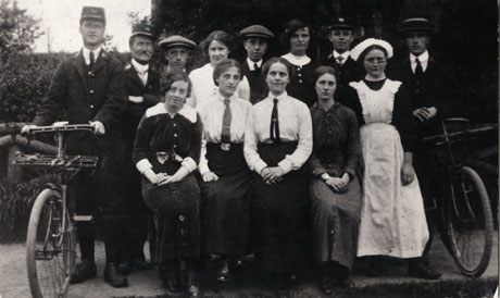 Photograph of the members of staff of the Post Office at Castle Eden, posed outside a building;the staff consists of seven women and six men; four of the men are in uniform and two of the men are holding bicycles