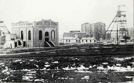 Photograph of the exterior of the surface buildings at Castle Eden Colliery, taken from short distance away, showing two substantial buildings, the winding houses, and the winding gear of the colliery
