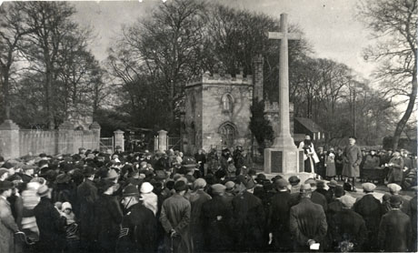 Photograph of a large group of people surrounding the war memorial at Castle Eden with two clergymen and a soldier of high rank, possibly on the occasion of the unveiling of the memorial on Remembrance Day