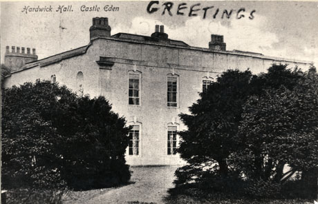 Postcard photograph entitled Hardwick Hall. Castle Eden showing the exterior of the building partly obscured by large bushes; the word Greetings is written on the photograph