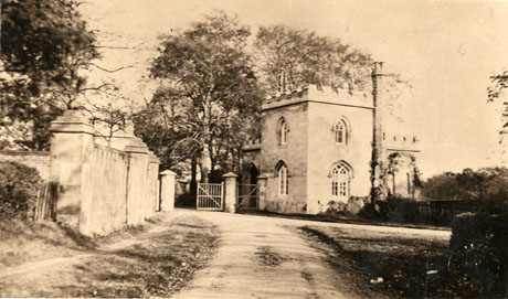 Photograph of a wall, open gate, and gatehouse, described as Entrance to Parklands, Castle Eden Dene