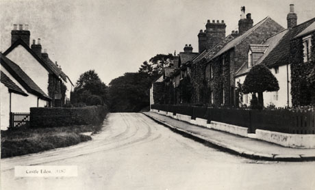 Postcard photograph entitled Castle Eden 3187, showing a road with houses on either side, leading away from the observer, and described as Entrance to Dene Lodge and Castle Eden