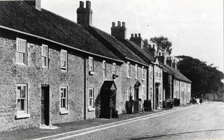 Photograph of the exterior of The Factory, Castle Eden, showing the front of the buildings taken at an angle from the road in front and showing four or five very indistinct people on the pavement