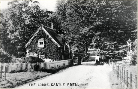 Postcard photograph entitled The Lodge, Castle Eden. No 1168 also described as Dene Lodge, showing the lodge before its extension, the road into the trees and the gateposts; the photograph is taken from a slightly longer distance than that in cast0046