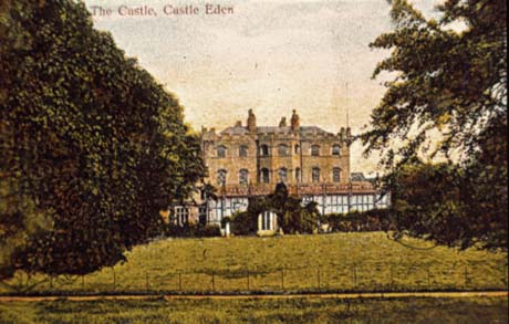 Postcard photograph entitled The Castle, Castle Eden, showing the facade of a large house with crenellations and a glass house; in front of the house are trees and an expanse of grass