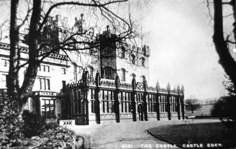 Postcard photograph entitled 2121 The Castle, Castle Eden, showing the front of the Castle, Castle Eden, in detail; the facade of the main part of the house may be seen and the glass porch in a more Gothic style which has been added to the front of the house, and which from a distance resembles a glass house, can also be seen