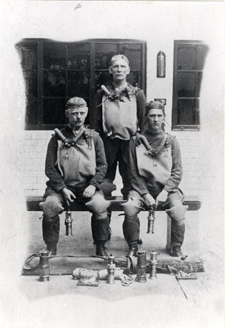 Photograph of three members of the Trimdon and Deaf Hill Miners' Rescue Team at the Houghton Rescue Team School; the members are posed with all their equipment