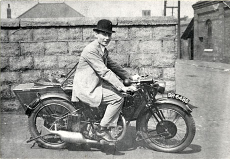 Photograph of a man in a suit and bowler hat sitting on a motor cycle with the registration number BR 6488; he is identified as Billy Ingram of Easington Colliery