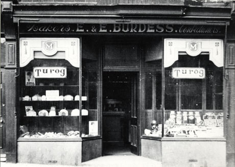 Photograph of the exterior of the premises of E. and E. Burdess, Bakers and Confectioners, showing the windows advertising Turog and displaying jars of sweets