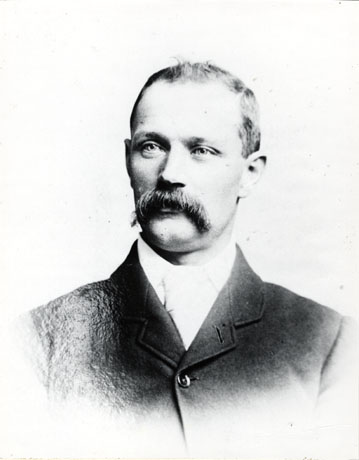 Photograph of a head and shoulders portrait of Thomas Parkin, showing a man with a moustache, wearing a jacket and collar and tie; he has been described as First Official, Easington Colliery
