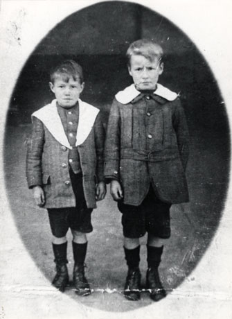 Photograph, full- length,of two boys, aged approximately eight and ten years, wearing Norfolk jackets with white collars, short trousers and boots; they are identified as The Welsh Brothers