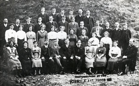 Photograph showing forty young men and women posed in four rows with a hillside behind them; they are dressed in suits and frocks and have been identified as members of St. John's Methodist Chapel, Easington Colliery on an outing