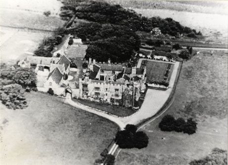 Photograph showing a castellated building, with other buildings and a garden, from the air; the building has been identified as Hawthorn Towers