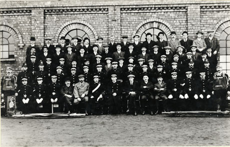 Photograph of a group of seventy four men posed outside what appears to be the colliery buildings at Horden; forty four men are dressed in suits and ties; twenty two are in uniform; four are in policemen's uniforms; two men are in mines rescue uniforms; the photograph has been described as Horden Officials
