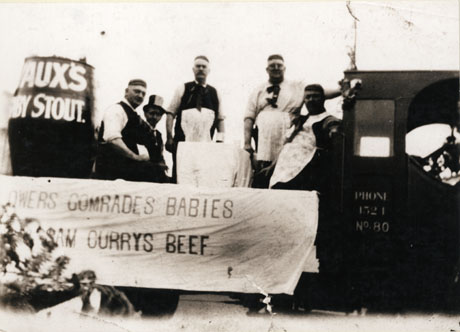 Photograph described as Horden Comrades' Carnival Float, showing five men standing beside a large barrel with the legend Vaux's ( )by Stout on it; the men are wearing aprons and in front of them is a banner reading ( )owers Comrades Babies ( )sam Currys Beef; to the right of the men is what looks like the cab of a locomotive with Phone 1321 No 80 on it