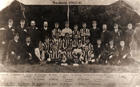Photograph of twelve men in a football strip flanked by thirteen other men, with two trophies in front of the players; above the photograph the date Season 1910-11 is printed; below the photograph the names of the men are given, as follows: back row: Lincoln; J. Naisbitt; C. Emery(Committee); R. Edwards(Committee); W. Price; T. Miller(Captain); W. Mackay: W. Scott; T. Parkin; W. Anderson(Chairman); S. Jones(Vice-Chair);J.Wilford; middle row: E. Wilford; S. Mould; J. Edwards(Treasurer); W. Edwards: J. Emery(Secretary); front row: W. Hall(Committee); H. Edwards(Committee); W. Fairhurst(Trainer); F. Jones; S. Williams(Vice Captain); T. Warlow; T. Cummings; J. Anderson(Financial Secretary); R. Cushlow; the photograph has been identified as First Football Team in Horden