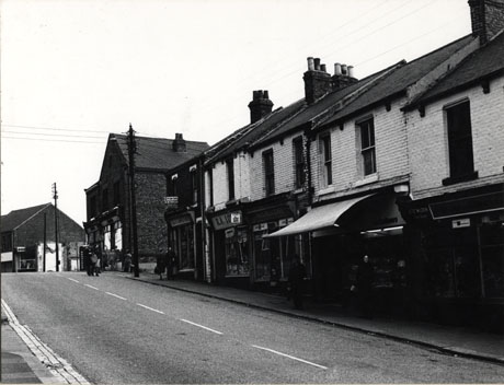 Photograph showing the facades of shops on the right-hand side of the top of Blackhills Road; the shops identifiable are: G. and E. Carruthers; R. A. Lo( ); K. and J. Bell, Cafe; R. and C. Wilson, Confectioners; the cinema at the top of the hill has been demolished and a branch of the TSB Bank can be seen at the top of the hill