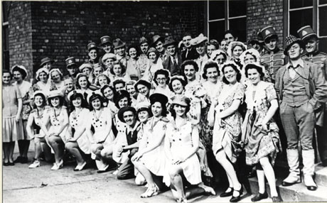 Photograph of forty five members of the cast of The Country Girl in costume photographed outside a brick building; the cast are members of the Horden Operatic Society