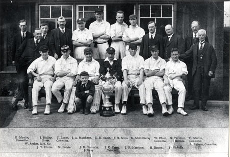 Photograph of the eleven members of the Horden Colliery Cricket Club, accompanied by eight other men and a boy; the club won the North East Durham League in 1925; the members have been named as follows: back row: E. Moody(Committee); J. Riding(Scorer); T. Lyons(Committee); J. A. Matthews; C. H. Saint; J. H. Mills; G. McGillivray; W. Blunt(Committee); G. Turnbull(Chairman); D. Martin(Committee); front row: W. Archer(Hon. Sec.); J. T. Dixon; N. Forster; J. R. Common; J. Gray; S. O. Prest(Captain); J. R. Harrison; E. Brown; P. Nicholls