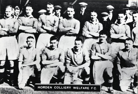 photograph of the eleven members of the Horden Colliery Welfare Football Club Team posed in front of a wall with the heads of seven indistinct men behind them; the photograph has been dated as 1937
