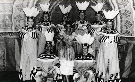 Photograph of nine members of the cast of Rose Marie in costume and grouped on stage in front of the scenery; the performers are members of the Horden and District Operatic Society