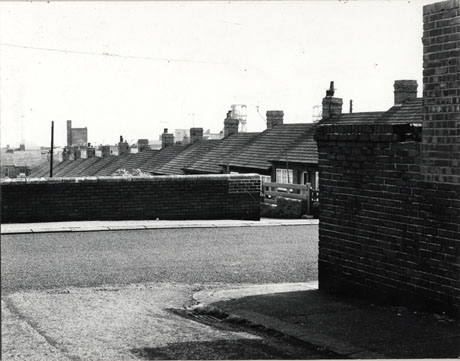 Photograph showing the roofs of bungalows descending a hill; in the foreground is a road running across the photograph and a low wall on the far side of the road; the roofs have been identified as those of bungalows in Newcastle Avenue, Horden