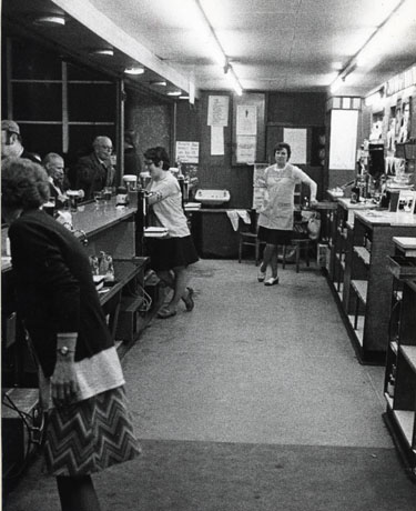 Photograph showing the area behind the bar at the Big Club, Horden, with three bar maids; four drinkers can be seen at the bar