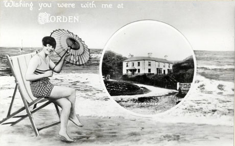 Postcard photograph entitled Wishing you were with me at Horden, showing a woman sitting on a deckchair on the beach, with an inset entitled Deneholme, showing the exterior of a large house with hills behind it