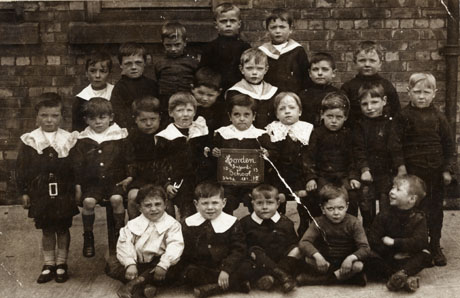 Photograph of a group of children twenty one children, aged approximately six years, posed against a brick wall; they have been identified as children at Horden Infants' School Photograph of a group of twenty three boys of the age of approximately six years, posed outside a brick building; a child on the front row is holding a notice which reads: Horden Infants' School 1913 549a No 15