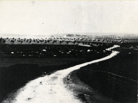 Photograph described as View of Horden From Ellison's Bank, 1911, showing the surface of a road running from the camera to the right, towards rows of terraced houses the roofs and chimneys of which can be seen; the details of the rest of the houses are indistinct