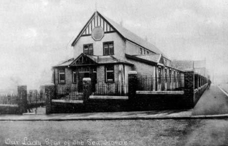Postcard photograph entitled Our Lady Star of The Sea, Horden, showing the exterior of the end and side of a two-storey building with sash windows, mock timbering, and single-storey extensions on its side and front; it is surrounded by a wall surmounted by railings