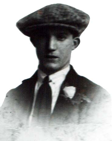 Photograph of the head and shoulders of a young man wearing a cap, jacket, collar and tie, and button hole; he has been identified as Chic Gray, Horden