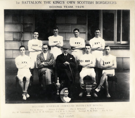 Photograph showing seven young men, wearing shorts and shirts with XXV on the front of the shirts, posed in two rows with one man in a suit and one man in an overcoat and cap; in front of the group are two trophy cups and an inset portrait of a the head and shoulders of a young man wearing a tartan; the photograph has a caption reading: 1st Battalion The King's Own Scottish Borderers Boxing Team, 1926 Winners Scottish Command Inter-Unit Boxing. Back Row, Left To Right: Private A. Hume; Bandsman P. Cairns; Private J. McKnight; Boy A. Conway; Front Row: Private W. Learmouth; Lieutenant H. M. Gillespie; Colonel P. A. V. Stewart, C.B.E., D.S.O.; Lance Corporal W. R. Pratt; Private R. Tait; Inset: Private J. Campbell