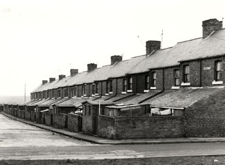 Photograph of a street of terraced houses viewed from the rear; the first flor windows can be seen as can the roofs of the lean to kitchens, outhouses and back walls; a street name reading: Temple Street can be seen on the first house