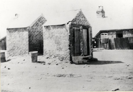 Photograph of two small brick sheds standing back to back; one can be seen to have two doors in it; behind the sheds a one- storeyed building can be seen in the distance; the sheds have been identified as outside lavatories in Albion Street, Murton; the lavatories have been demolished since the photograph was taken