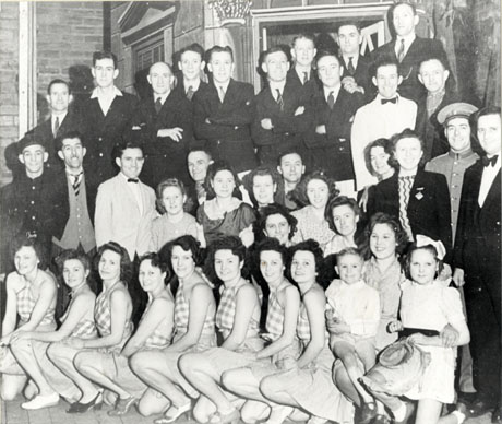 Photograph of the cast, in costume, of the Murton Amateur Operatic Society's production of Virginia; the cast are grouped on the stage in front of the scenery for the production; there are thirty nine people, including a girl of approximately seven years and a boy of approximately four years