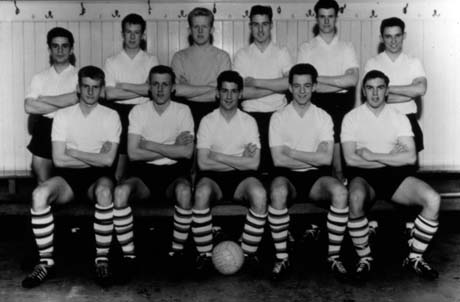 Photograph of eleven boys, aged approximately sixteen years, in football strip, posed against the walls of a dressing room; the photograph has ben identified as School Boys International Match - John Cocking - Murton