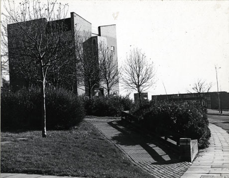 Photograph of the exterior of a large brick building in a modern style; on the right of the picture, a lower building can be seen in the distance; the photograph has been identified as Peterlee,1976