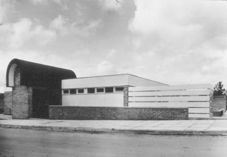 Photograph showing a low single-storey building with high shallow windows and a curved structure adjoining it on the left and a fence on the right; it has been identified as Central Youth Club, Peterlee