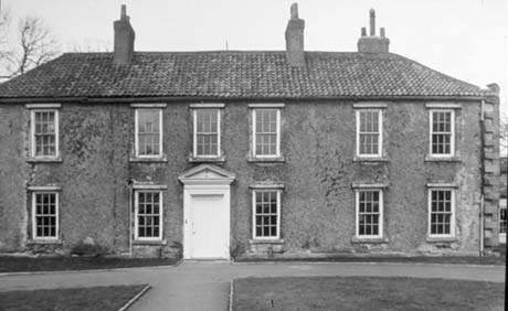 Photograph of the front of two-storey building with six sash windows on the first floor and five on the ground floor; the doorway is plain with a pediment; the roof is of tiles; it has been identified as Shotton Hall