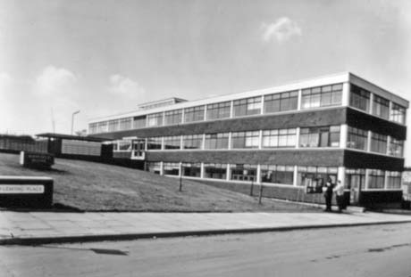 Photograph of the exterior of an oblong block of three storeys, consisting of windows; a piece of grass and a sign reading Fleming Place can be seen; the block has been identified as Hatfield House, Peterlee