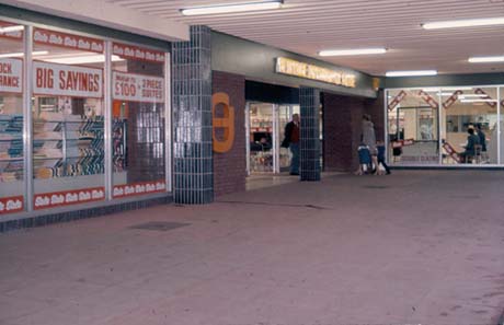 Photograph showing the entrance and five windows of the Fine Fare Superstore in Peterlee; signs advertising a Sale and three-piece suites and double glazing can be seen in the windows; a woman and two children are entering, and a man is leaving, the shop