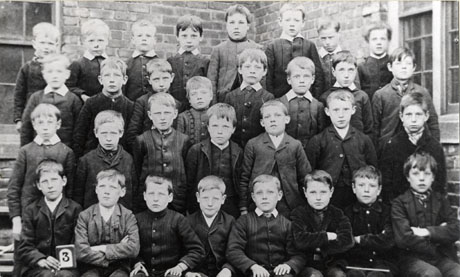 Photograph of thirty one boys, aged approximately ten years, posed in the angle of the walls of a brick building; a child on the front row is holding the number 3; they have been identified as pupils at Londonderry School, Seaham
