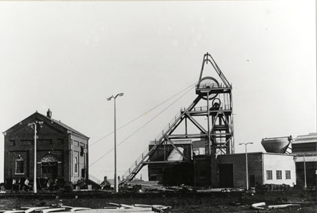 Photograph of the exterior of the engine house and of the pulley wheel at Low Colliery Pit, Seaham; a low building and sodium street lights can also be seen in the picture