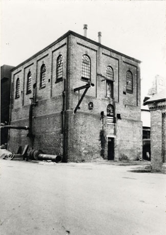 Photograph of the exterior of a brick building with windows on its upper storey, presumably the engine house at a colliery; the picture is identified as South Pit Winding, Shotton, 12 April 1957